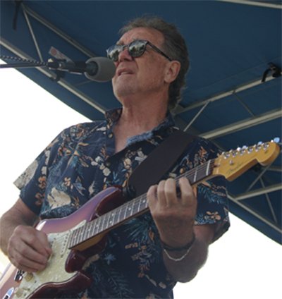 Michael C singing and playing guitar with The Stragglers